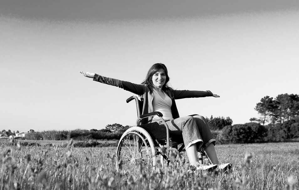 Woman sitting in a wheel chair in a field